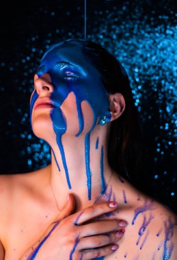 Boyalı genç bir kadın. Sıvı boya güzel bir yüzün ve vücudun üzerinden akıyor. Boyalı Kız 'ın Renkli Portresi