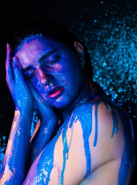 Boyalı genç bir kadın. Sıvı boya güzel bir yüzün ve vücudun üzerinden akıyor. Boyalı Kız 'ın Renkli Portresi