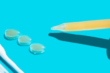 Mavi arka planda bir doz sıvı hyaluronik asit olan bir boru. Kozmetik konsepti. Düz yat. Tex için yer