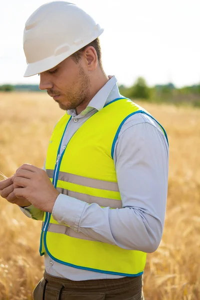 Portrait of an electrical engineer, field engineer, foreman, owner, standing at a construction site, and a power line and a pole in the background, an engineer of Caucasian white