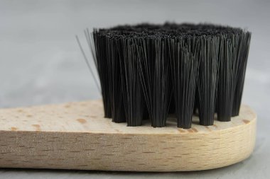 Wooden massage brush close-up for anti-cellulite massage and spa procedure lies on a wooden table