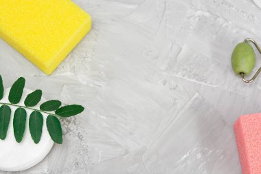 Cotton pads for makeup and white cotton swab green leaves, gray concrete background, nature spa concept, top view, fatlay, for copy space or product display