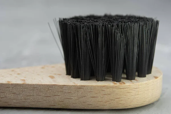 Wooden massage brush close-up for anti-cellulite massage and spa procedure lies on a wooden table