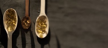 Omega 3 vitamini, spor, vitamin, sağlıklı yaşam tarzı, beslenme malzemeleri, vitamin terapisi, spor takviyeleri içeren tahta kaşıklar.
