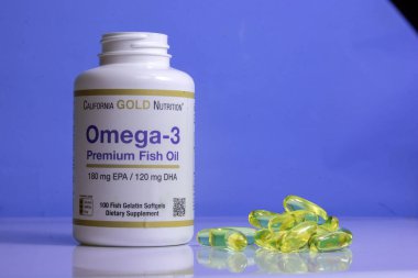 Masada bir kavanoz omega 3 vitamin, vitaminler mavi arka planda omega 3 vitaminli ahşap bir kaşık sağlıklı yaşam tarzı, beslenme takviyeleri, vitaminler, sağlık