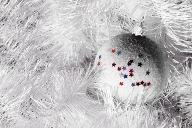 Renkli yıldızlarla süslenmiş Noel balosu. Yakın plan. Gri tonlar.