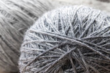 Clew of dark gray melange threads close-up. Selective focus in the foreground.
