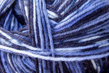 The threads of the combined yarn are sectionally dyed blue. Soft selective focus.