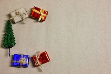 Mutlu Noeller, mutlu yıllar ve boks günü konsepti. Mevcut kutular, alışveriş arabası, çam ağacı ve açık kahverengi arka planda ev modelleri..