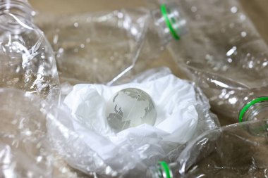 Plastik kirliliği. Boş plastik şişe, plastik torba ve masada kum saatinin içinden geçen Wolrd marka kristal bardak. Küresel warimg konsepti için geri sayım zamanlayıcısı.