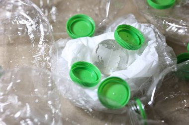 Plastik kirliliği. Boş plastik şişe, plastik torba ve masada kum saatinin içinden geçen Wolrd marka kristal bardak. Küresel warimg konsepti için geri sayım zamanlayıcısı.