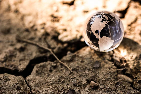 气候变化或全球变暖的概念 干旱土地上的世界水晶杯子 — 图库照片
