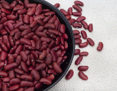 Köy yüzeyinde pişmemiş bir kase pişmemiş kırmızı böbrek fasulyesi.