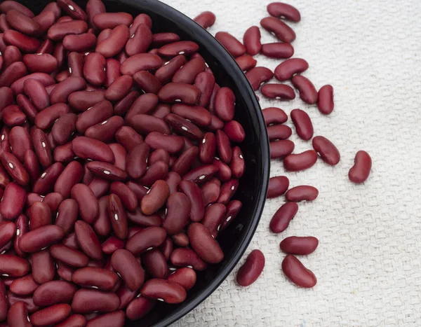Köy yüzeyinde pişmemiş bir kase pişmemiş kırmızı böbrek fasulyesi.