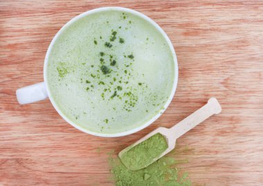 Yeşil Matcha Latte, bir kepçe toz kibrit tozu ile kırsal masada.