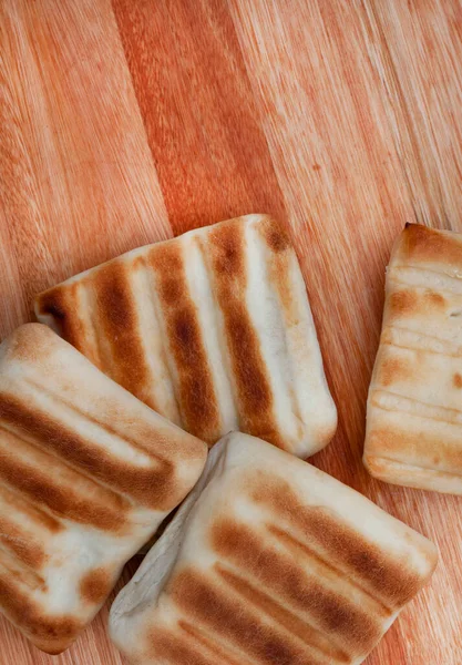 Geleneksel Güney Afrika Braai ekmekleri ya da horoz yavruları, açık ateşte kırsal tarzda pişirilmiş.