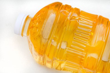  2 litrelik bir ayçiçeği şişesinin üst kısmı beyaz yüzeyde fotokopi alanı olan yağ pişiriyor.