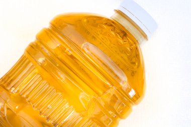  2 litrelik bir ayçiçeği şişesinin üst kısmı beyaz yüzeyde fotokopi alanı olan yağ pişiriyor.