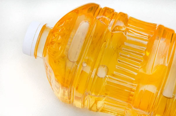  2 litrelik bir ayçiçeği şişesinin üst kısmı beyaz yüzeyde fotokopi alanı olan yağ pişiriyor.