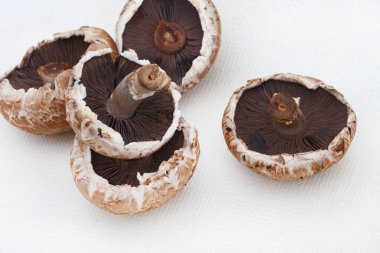 Portobello mantarları üzerine istiflenmiş ve kopyalama alanı olan beyaz bir arkaplanda izole edilmiş.