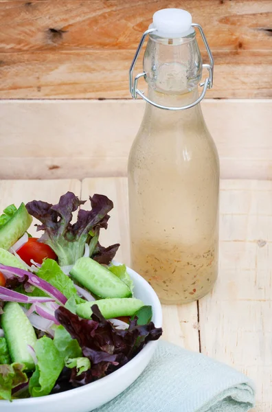 homemade salad dressing with side salad on rustic table with copy space