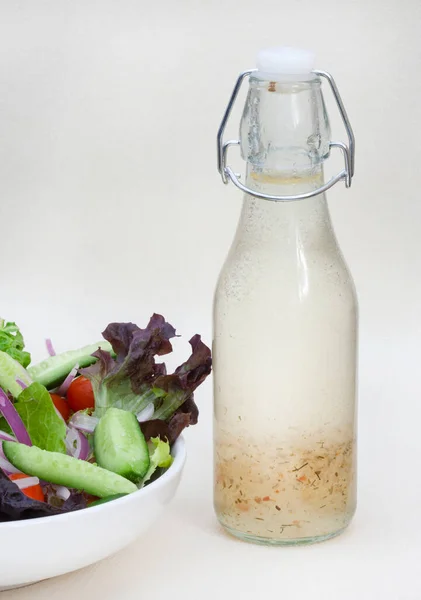 homemade salad dressing with side salad on rustic table with copy space