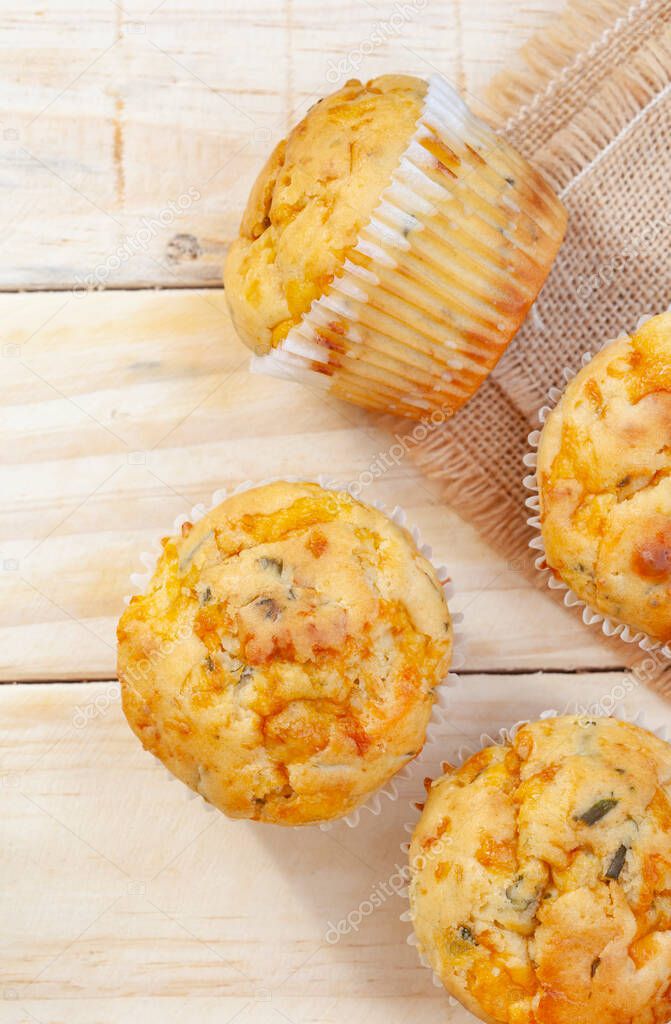 cheese and herb savory muffins baked to cheesy perfection on a rustic surface