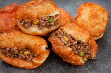 Güney Afrika vetkoek, bol yağda kızartılmış tuzlu hamur aromalı tatlandırıcı, benekli gri arkaplan ve fotokopi alanı
