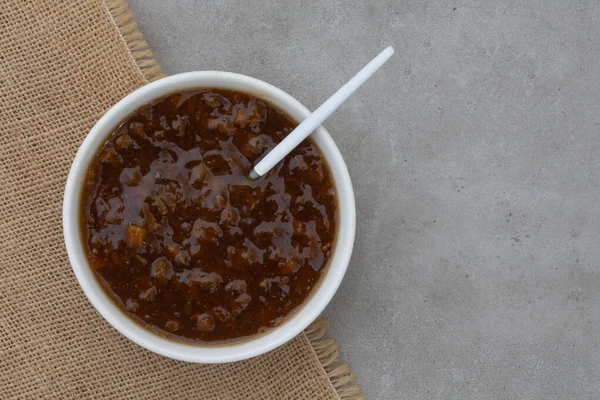 Geleneksel Güney Afrika meyve turşusu. Fotokopi alanı olan beyaz bir kase içinde popüler bir sos.