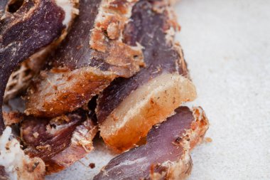 Güney Afrika Biltong 'u, kurutulmuş ve kurutulmuş et dilimlenmiş ve arka planda fotokopi alanı olan gri bir yer.