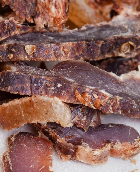 Güney Afrika Biltong 'u, kurutulmuş ve kurutulmuş et dilimlenmiş ve arka planda fotokopi alanı olan gri bir yer.