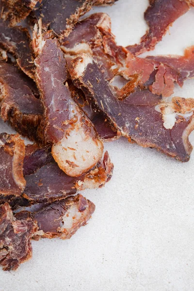 Güney Afrika Biltong 'u, kurutulmuş ve kurutulmuş et dilimlenmiş ve arka planda fotokopi alanı olan gri bir yer.