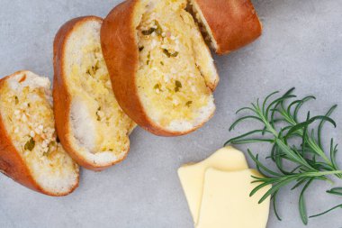 Taze pişmiş sarımsaklı ekmek, kopyalanmış gri yüzeyde yatıyordu.