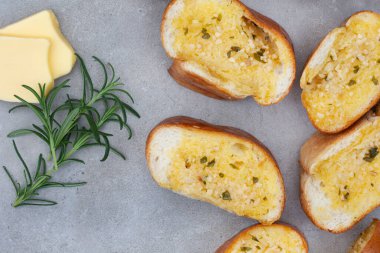 Taze pişmiş sarımsaklı ekmek, kopyalanmış gri yüzeyde yatıyordu.