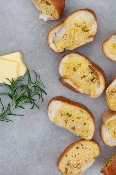 Taze pişmiş sarımsaklı ekmek, kopyalanmış gri yüzeyde yatıyordu.