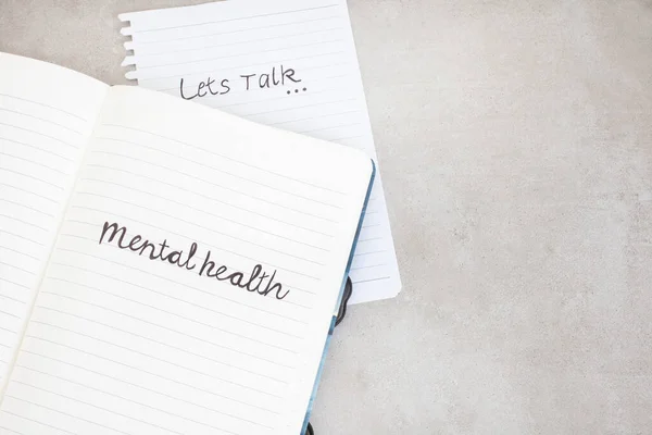 lets talk mental health. Handwritten on notebook with grunge or rustic background and copy space
