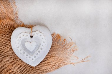 benekli gri yüzey üzerinde çuval bezi ve beton kalp ile arkaplan çerçeveleme resmi kopyalama alanı ile