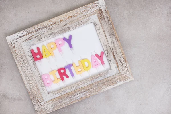 happy birthday candles in rustic frame on grey with copy space