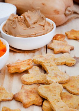 homemade organic dog biscuit treats and ingredients on raw wood with copy space