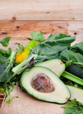 Avokado ve sebzeler kırsal masada çuval bezi ve kopyalama alanı ile