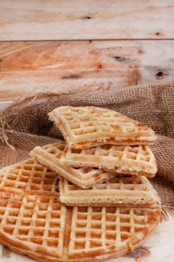 Çuval bezi ile çiğ ahşap üzerinde sade waffle.