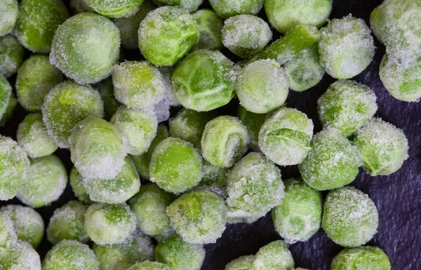 Frozen Green Garden Peas Covered Ice Black Surface Selective Focus — Stock fotografie