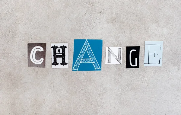 Change, written with lettering from magazine clippings on mottled grey