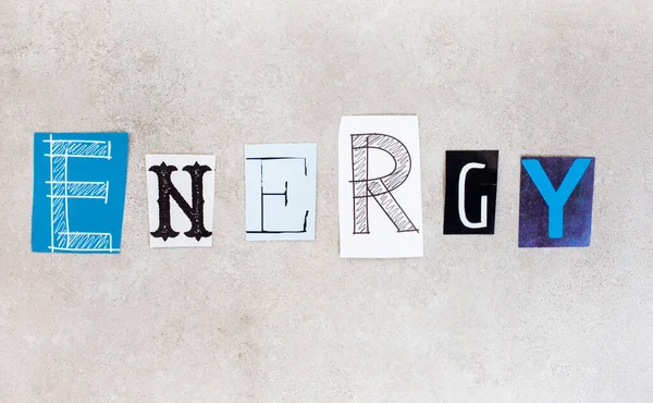 Energy, written with lettering from magazine clippings on mottled grey