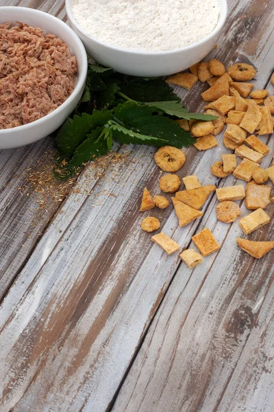 Homemade special tuna cat treats on rustic white wooden table with ingredients and copy space