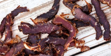 Geleneksel Güney Afrika biltong dilimlenmiş ya da kırsal beyaz ahşap yüzeyde pişirilmiş et