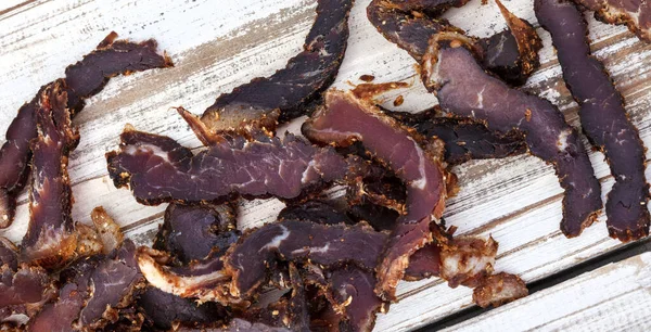 Geleneksel Güney Afrika biltong dilimlenmiş ya da kırsal beyaz ahşap yüzeyde pişirilmiş et