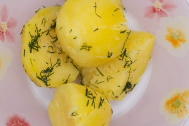 Güzel bir tabağa dereotu serpiştirilmiş lezzetli haşlanmış patates.