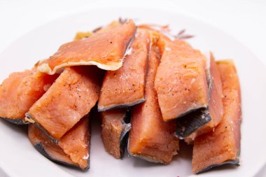 Bulanık bir tabakta dilimlenmiş lezzetli tuzlu balık.