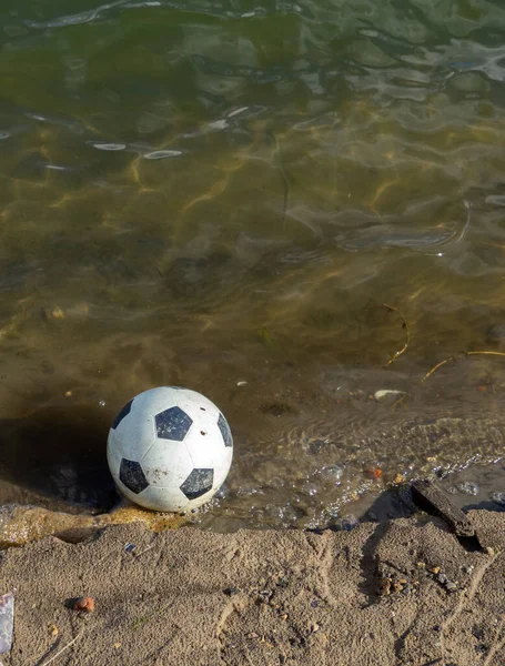 Soccer ball in the water. The ball fell into the rive